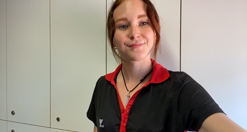 Young woman wearing red and black uniform taking a selfie